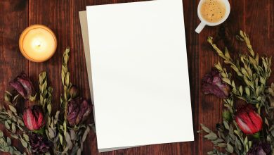 a blank paper next to a cup of coffee and flowers