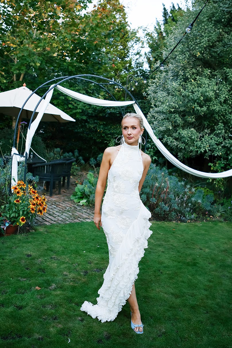 bride amy shaw in her second dress on her wedding day, a rotate birger christensen high neck floral embroidered dress with an asymmetric ruffled hem rented from by rotation